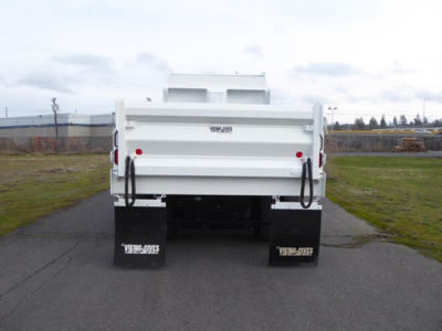 Back view of a white Mack MD6 dump truck showing dual rear-dump bed, black mud flaps with white text, and tailgate area.