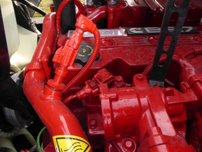Mack MD6 engine bay with red components and wiring harness visible.