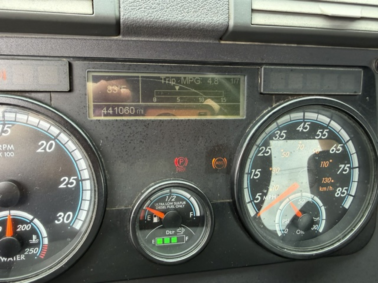Dashboard of a Freightliner Cascadia showing gauges including RPM, speedometer, trip MPG display, and fuel/engine indicators.