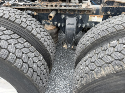 Freightliner Cascadia chassis center showing dual rear axles and suspension components with tires visible.