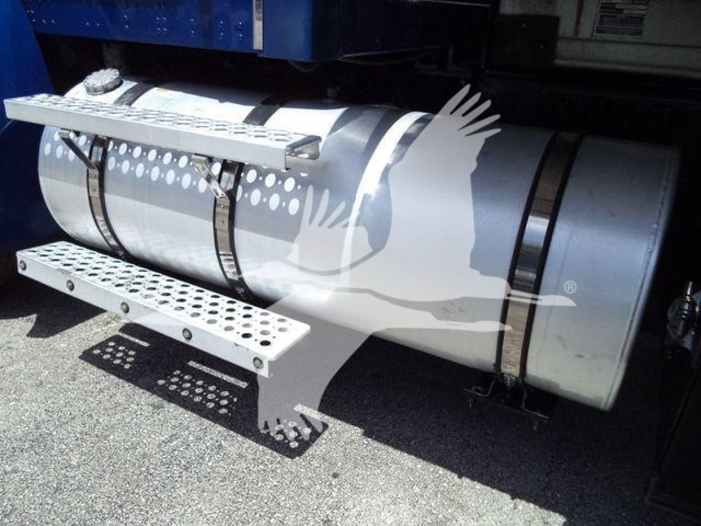 Kenworth fuel tank under side of truck with perforated metal steps and mounting straps.