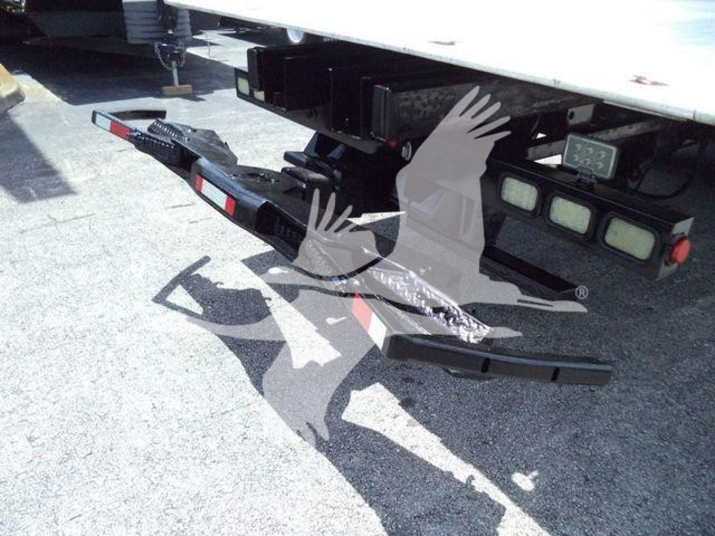 Rear view of a 2016 Kenworth T370 rollback truck showing the towing hitch with safety chains and rear bumper assembly.