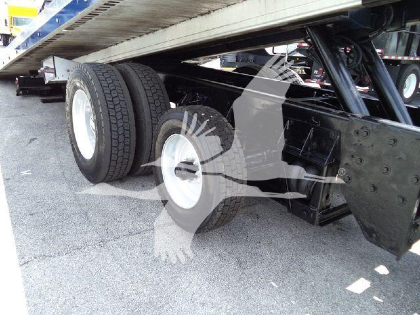 Kenworth T370 rollback truck undercarriage showing dual rear axles with tires and suspension, including underbody frame and hitch area.