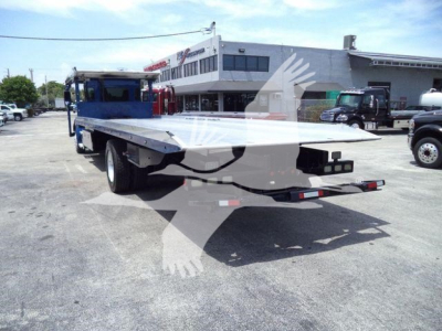Kenworth T370 rollback tow truck with flatbed open, rear view showing bed extended and wheel surfaces.