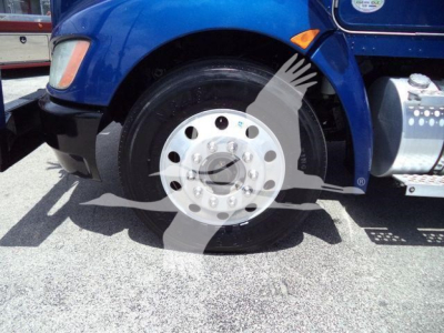 Kenworth T370 front wheel and fender with a polished steel hub and blue cab in a rollback truck sale photo.