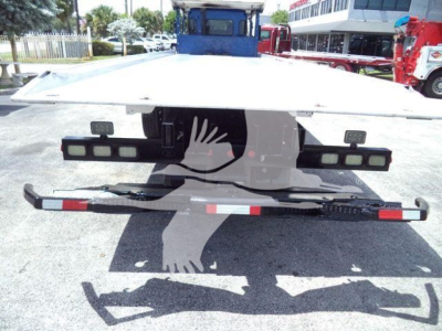 Rear view of a 2016 Kenworth T370 rollback truck showing a flatbed with side rails and bumper with reflectors.
