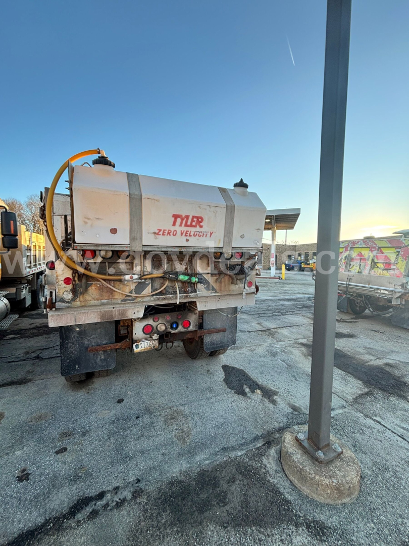 Rear view of a Sterling L8500 vacuum/maintenance truck with a TYLER Zero Velocity tank, hoses, and rear storage; visible license plate area and taillights.