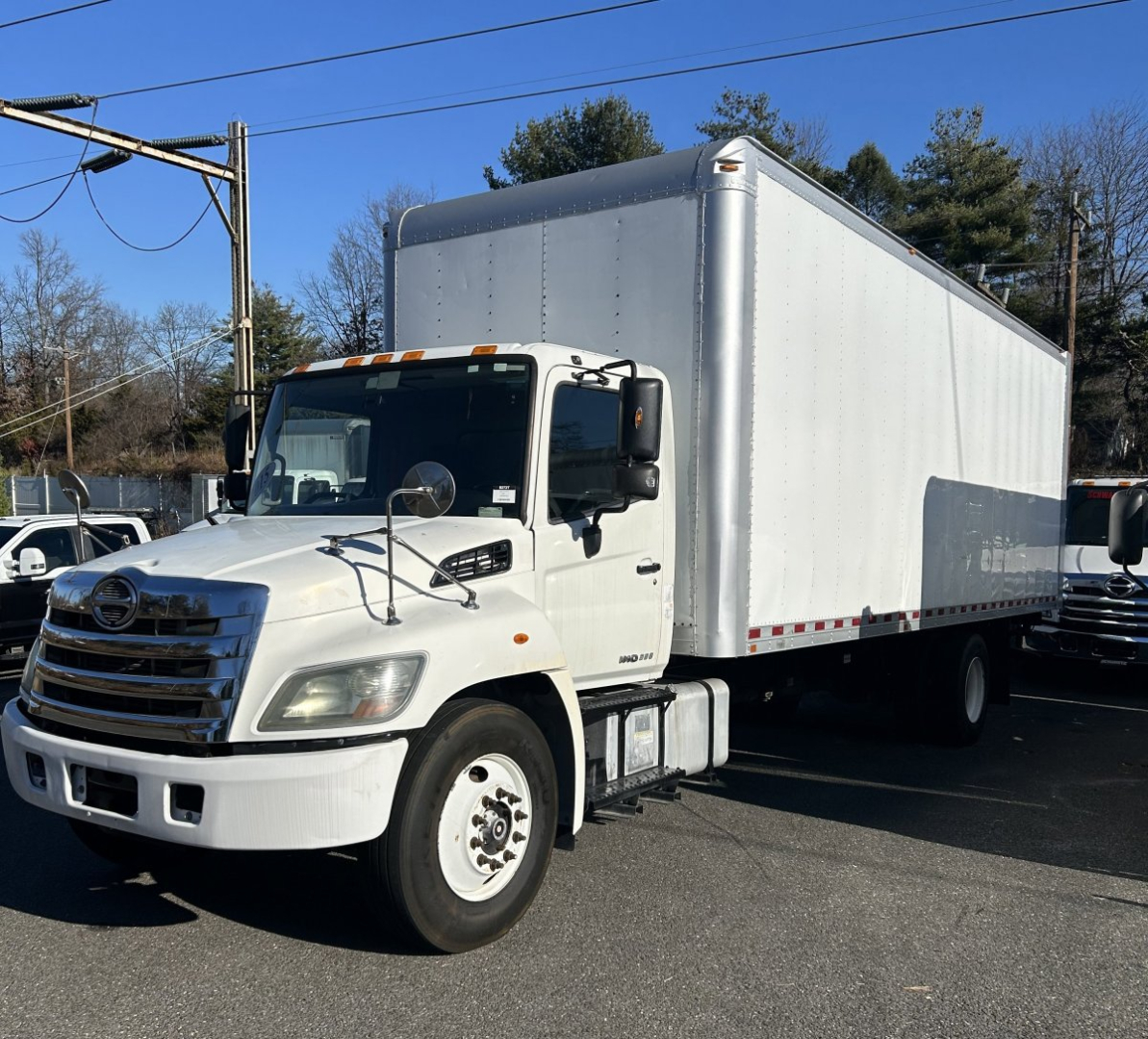 Box Van truck showing front and side view with white cab and large rectangular cargo box.