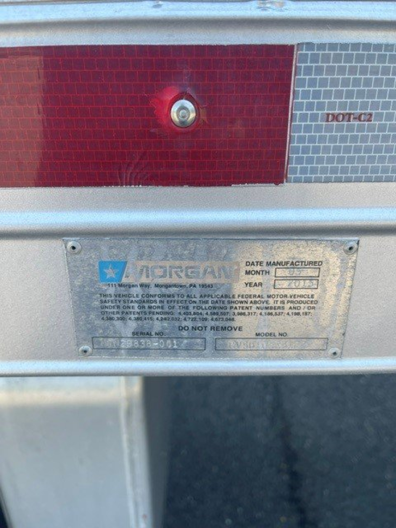 Truck rear with Morgan body plate and taillight sections visible. Metal identification plate shows VIN/serial, and DOT-C2 reflector panel.
