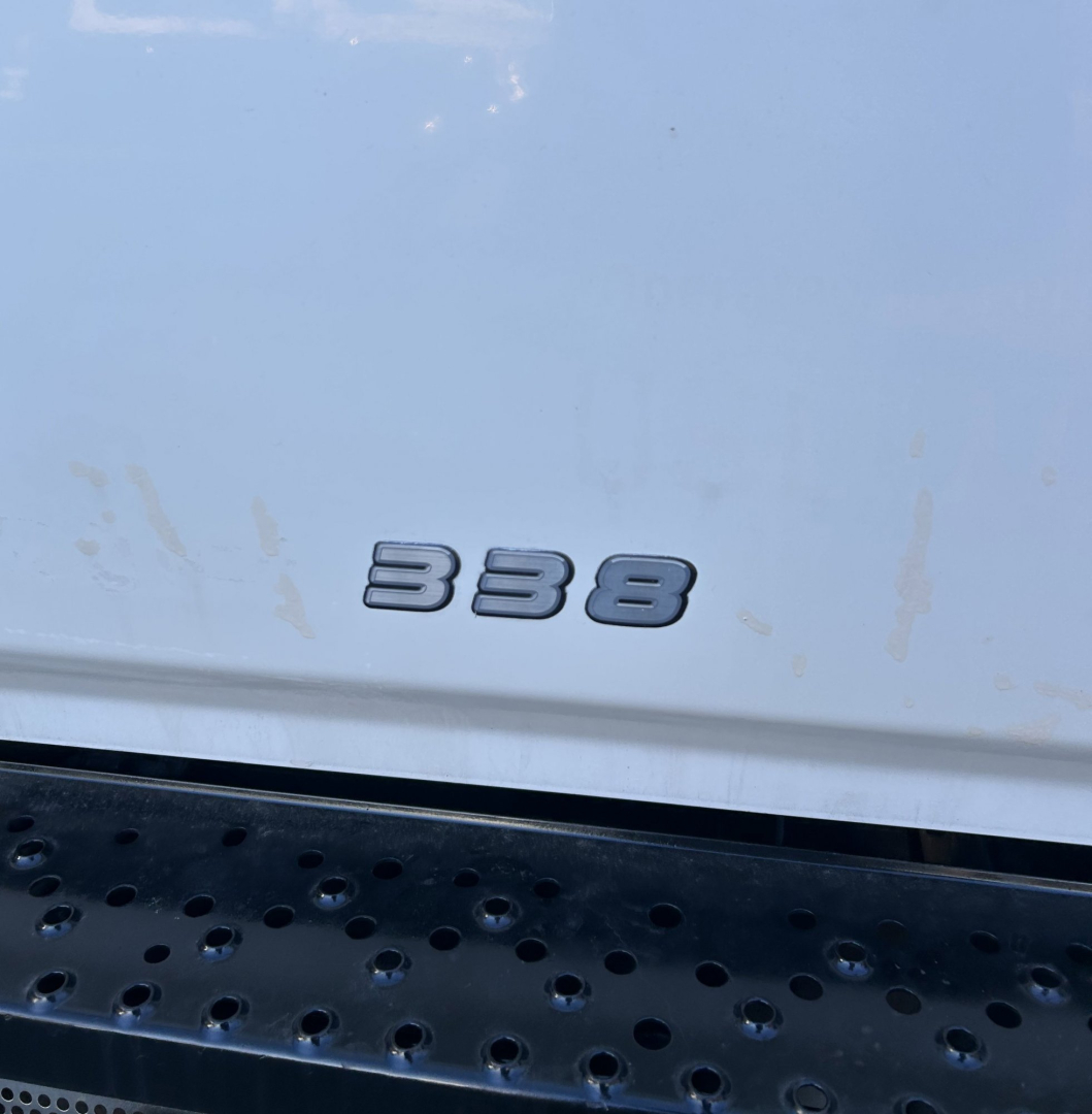 Truck rear showing '338' badge on tailgate for 2015 Hino 338 with perforated step bumper.