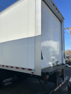 Hino 338 box truck rear corner and cargo area with white exterior and rear bumper.