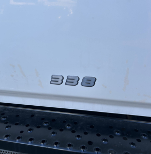 Truck rear showing '338' badge on tailgate for 2015 Hino 338 with perforated step bumper.