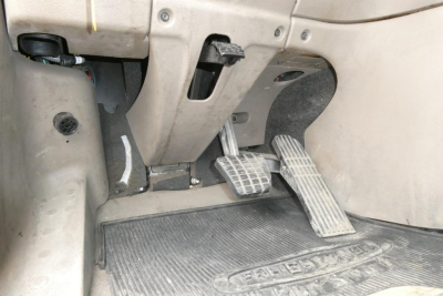 Pedals and accelerator area of Freightliner Cascadia 125 interior view with floor mat and driver controls.