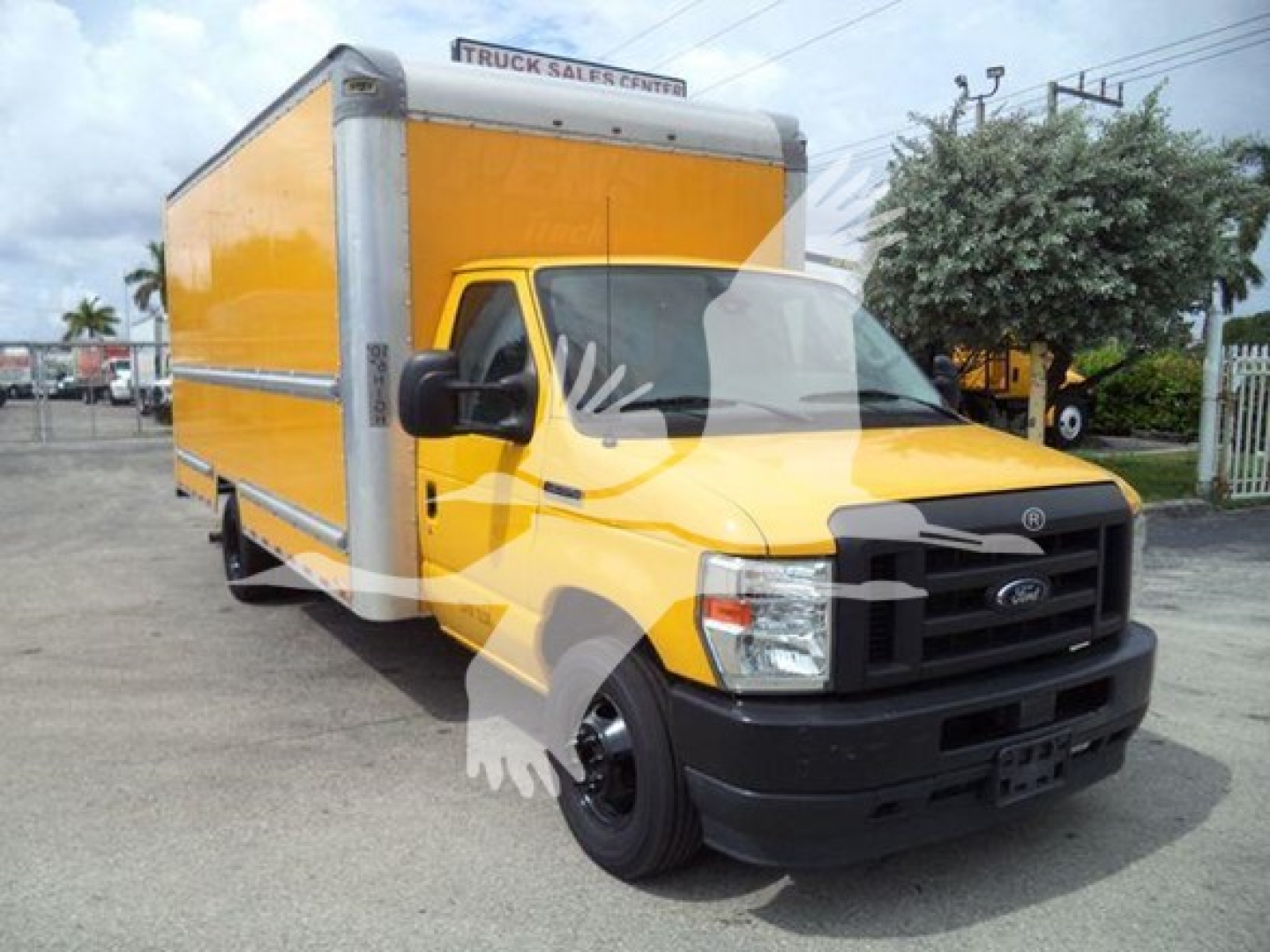 Ford E-350 box truck in service color yellow with large cargo box, front view showing cab and box; stock number T04043 and dealership lot background.