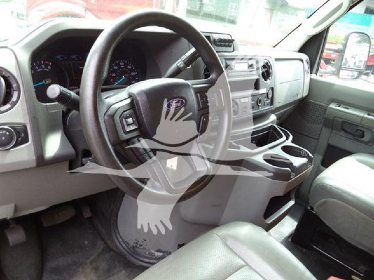 Ford E-350 cabin interior showing steering wheel, dashboard, center console, and front seats.