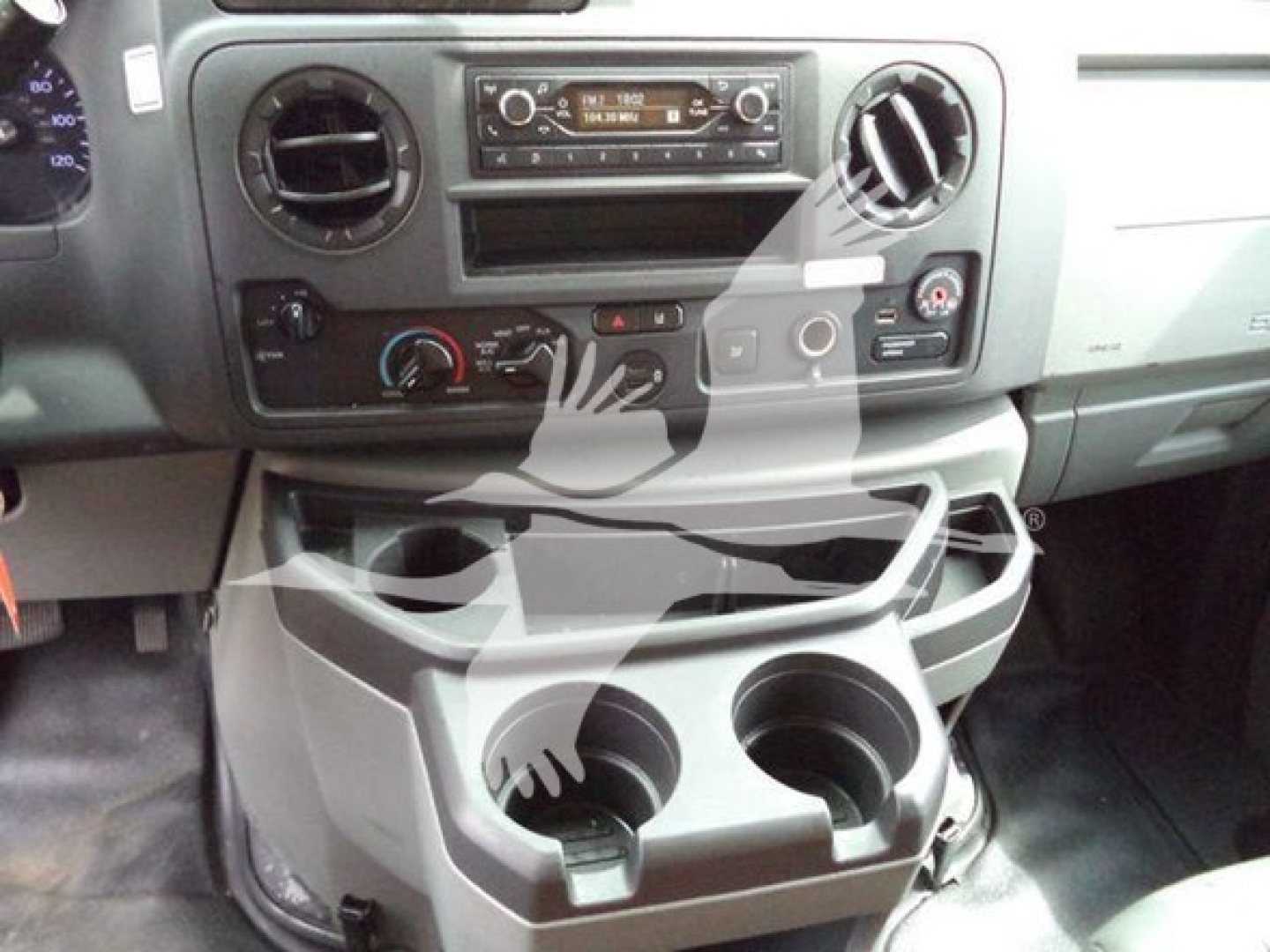 Dashboard of a Ford E-350 interior showing center stack with radio, climate controls, and cup holders below. Overlay watermark obscures some area.