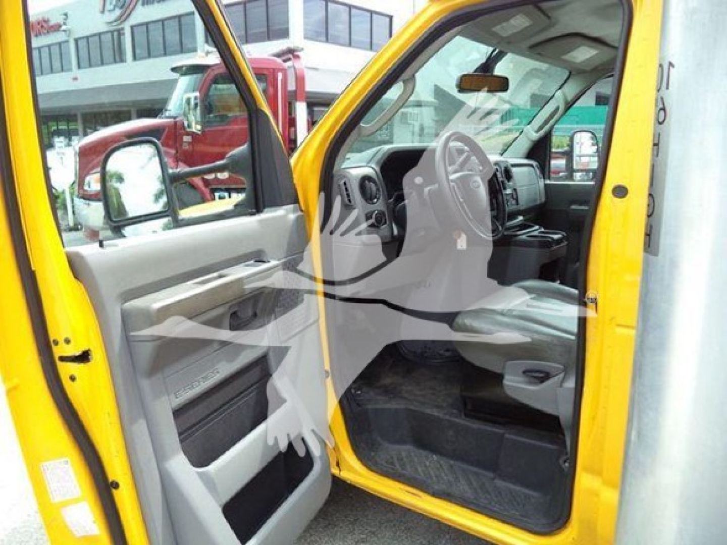 Ford E-350 XD? interior view with open driver door showing steering wheel dashboard and front seat area.
