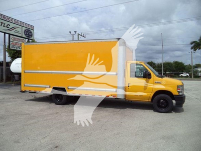 Ford E-350 box truck in service bay showing yellow cargo box and white cab with stock number T04043 and VIN 1FDWE3FN1NDC04043