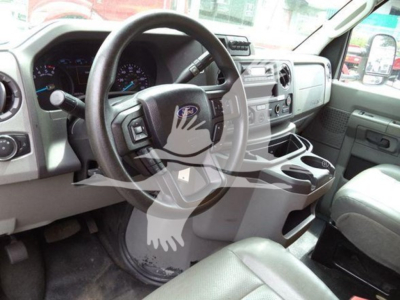 Ford E-350 cabin interior showing steering wheel, dashboard, center console, and front seats.