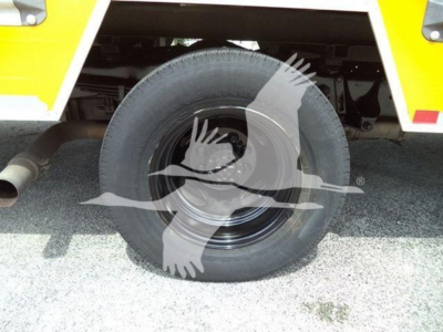 Ford E-350 cutaway high cube side view showing single rear wheel and fuel exhaust area.