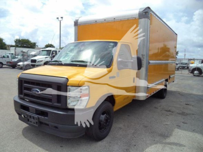 Ford E-350 cargo box in yellow and gray cab front view with black bumper and wheel, daylight; no visible model stickers.
