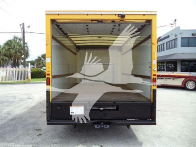 Rear view of a yellow delivery box truck with open cargo area; no visible text inside the image.