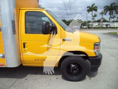 Ford E-350 cutoff side view showing yellow cab with black front bumper and wheel, van box attached. Visible text on door and fender