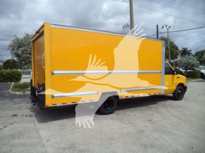 Ford E350 XL cutaway truck with bright yellow cargo box mounted on chassis, side utility doors and rear doors visible, stock image of work vehicle