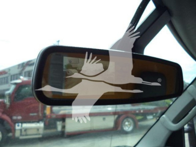 Rearview mirror showing reflection of truck in background.