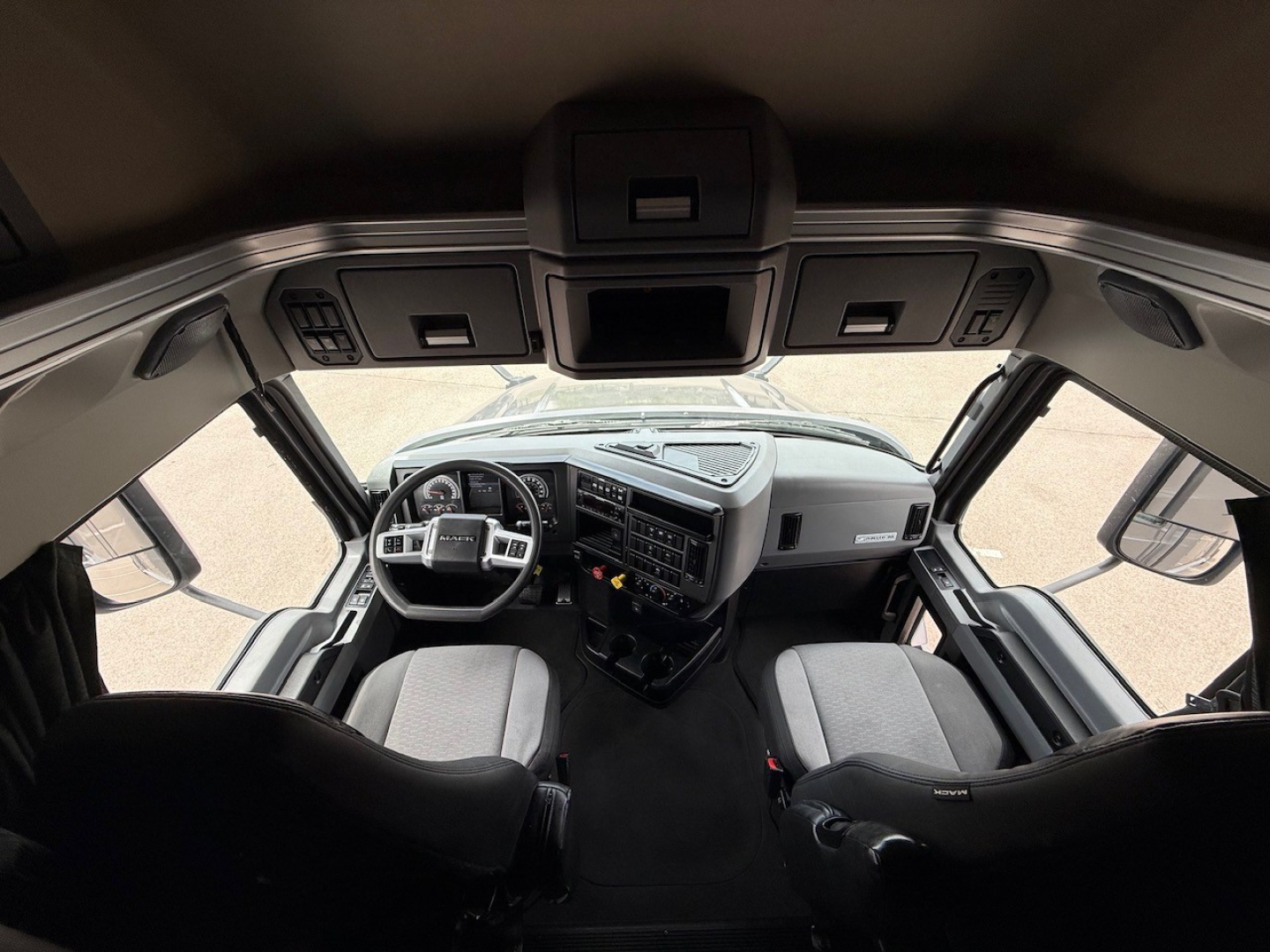 Mack ANTHEM truck cockpit showing steering wheel and dashboard with overhead controls.