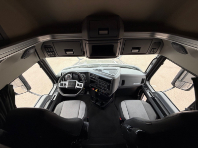 Mack ANTHEM truck cockpit showing steering wheel and dashboard with overhead controls.
