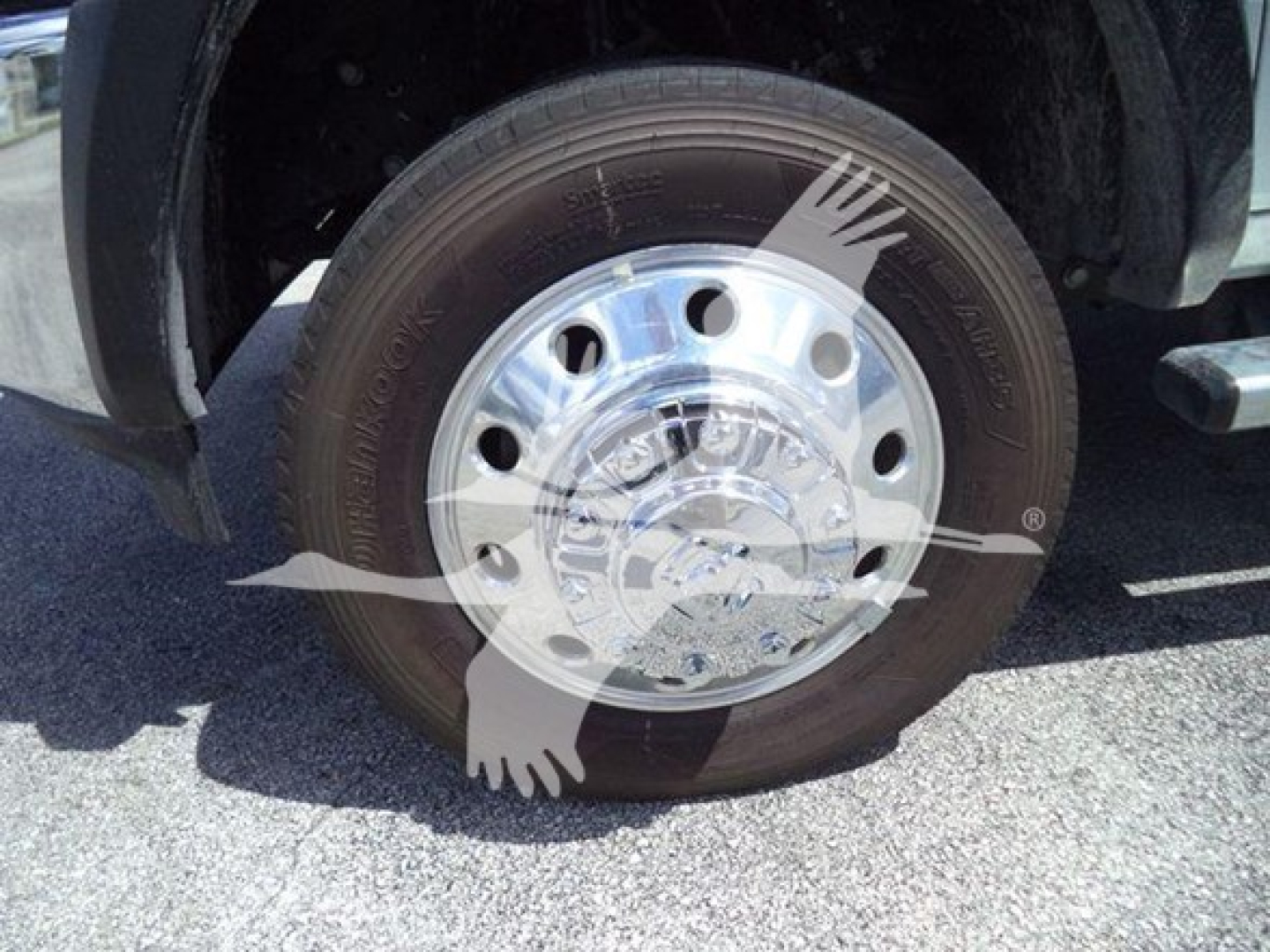 Wheel with chrome hubcap and tire on Ram 5500 front suspension showing polished hubcap and tire tread