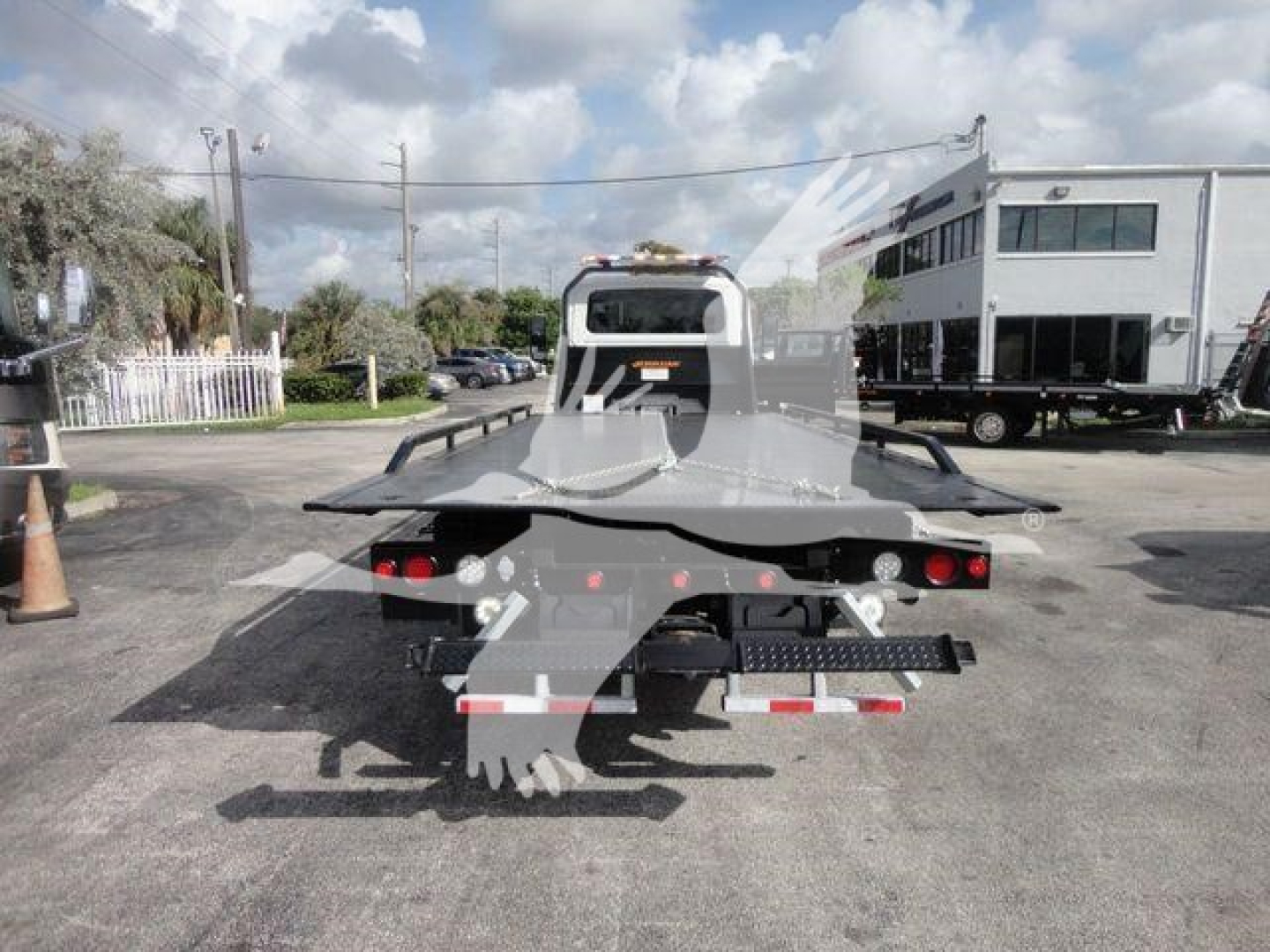 Tow truck flatbed with MV607EXCAB22XLP stock number, rear view showing hydraulic winch, lights, and flatbed; no visible branding details beyond generic truck components.