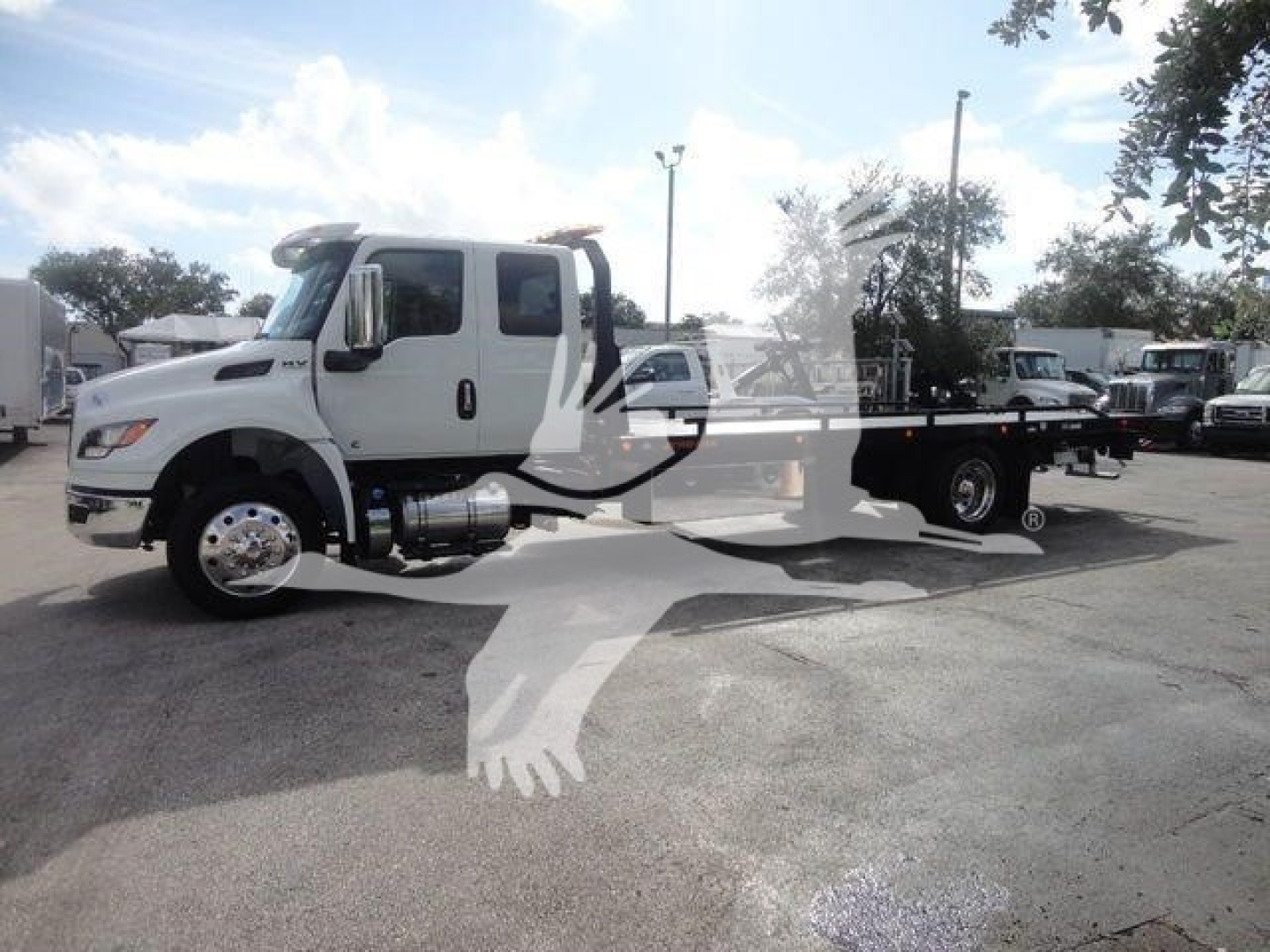 White International MV tow truck, side view, with flatbed, dual rear wheels, chrome fuel tank, and side mirrors.