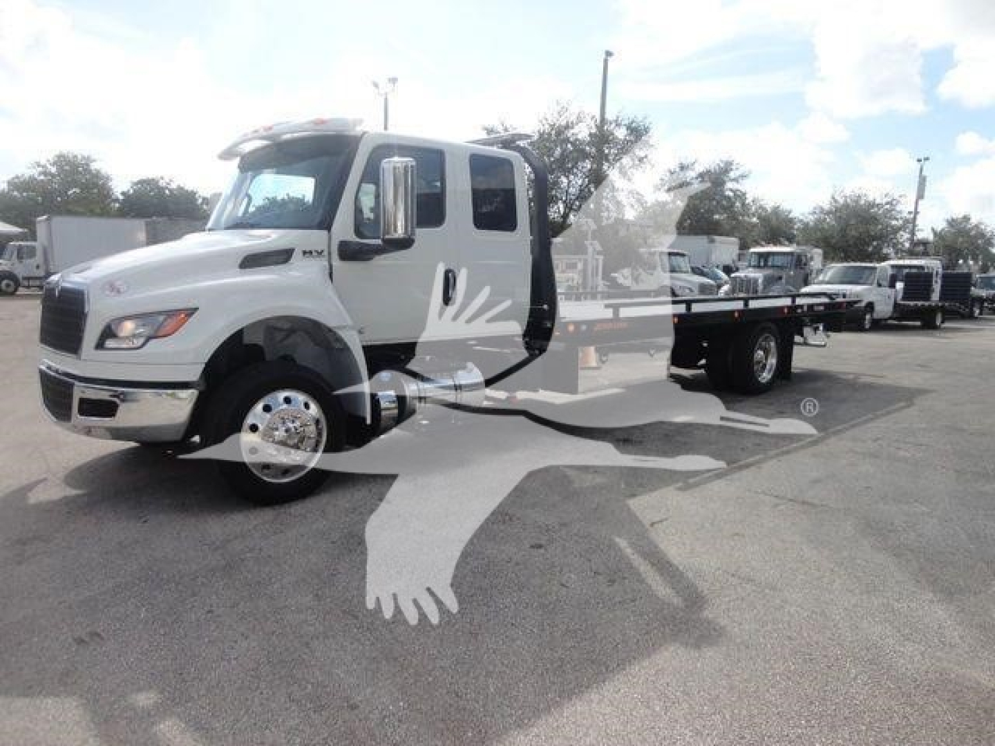 International MV rollback truck showing cab and flatbed with watermark graphic on image.