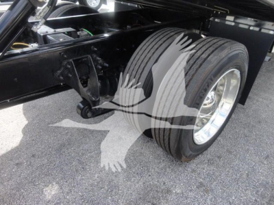 Truck front dual rear wheels on a component frame with leaf spring suspension and black chassis visible.