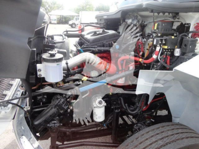 MV607EXCAB22XLP engine bay of a 2027 International MV rollback truck showing air intake, hoses, wiring, and fluid reservoirs.
