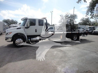 White International MV tow truck, side view, with flatbed, dual rear wheels, chrome fuel tank, and side mirrors.