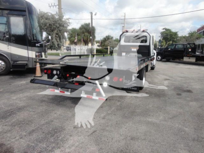 Vehicle rear view showing rollback tow truck bed and winch assembly with taillights and bumper.