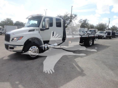 International MV rollback truck showing cab and flatbed with watermark graphic on image.