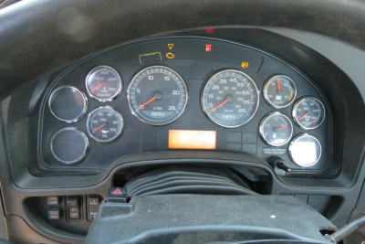 Dashboard of a 2012 International PROSTAR+ 122 truck showing analog gauges and warning lights, with steering wheel and instrument cluster visible.