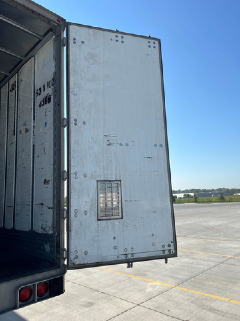 Trailer side door of a 2014 utility van showing an interior and open rear with a small vent on the back panel.