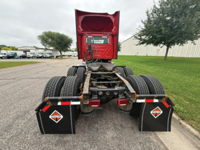 Rear view of a 2019 International LT625 truck tractor cab chassis showing dual rear axles, mud flaps with diamond logo, red fifth wheel housing, and exposed drivetrain.