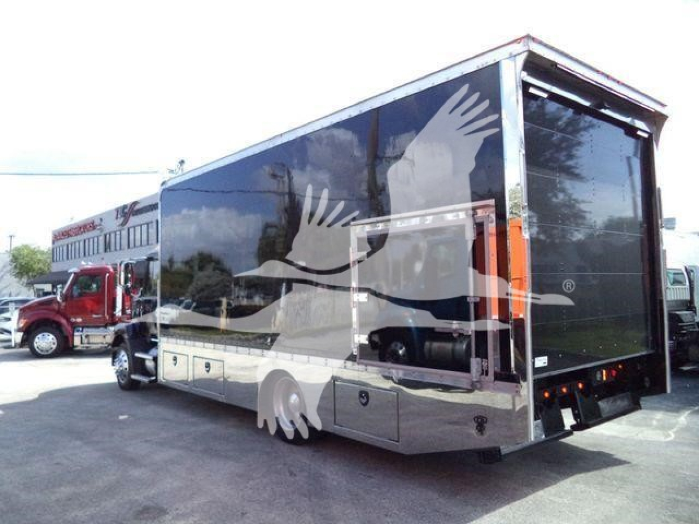 MD6 rear view showing truck with large enclosed rollback cargo area and reflective twin wheel arches.