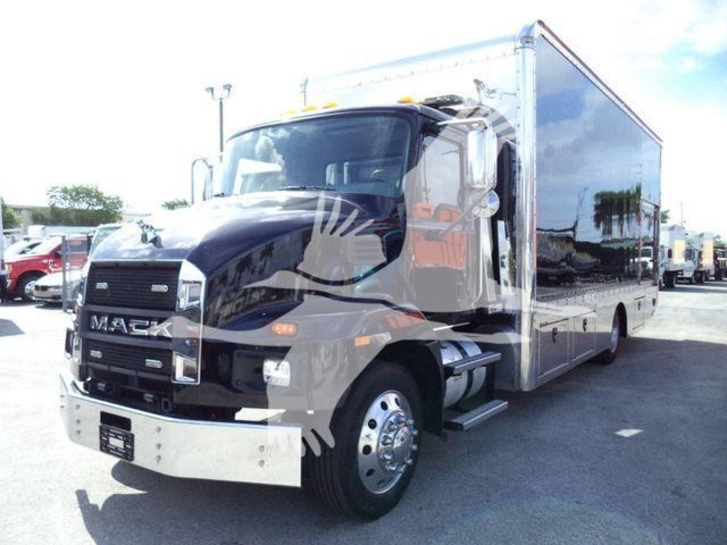 Mack MD6 rollback truck in black with chrome bumper and large cargo box, front grille with Mack emblem, side mirrors, and dual rear wheels.