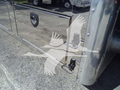 Truck side panel with metal toolbox and latching handle; chrome stainless surface reflecting surroundings.