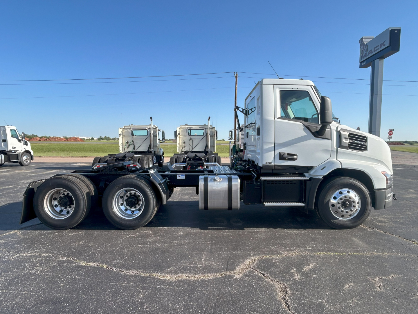 Mack AN64T conventional daycab truck side view showing chassis and cab with two rear axles and dual fuel tanks.