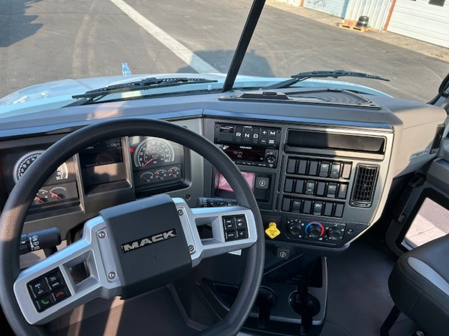 Mack AN64T truck cabin interior showing steering wheel and dashboard with gauges and control panels.
