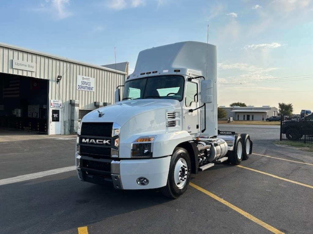 Mack AN64T truck in a parking lot showing front grille and cab with sleeper, white exterior.