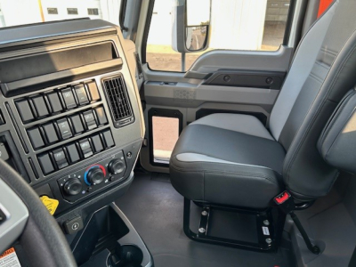 Cab interior of a 2025 Mack AN64T daycab showing front dash with climate controls and passenger seat.